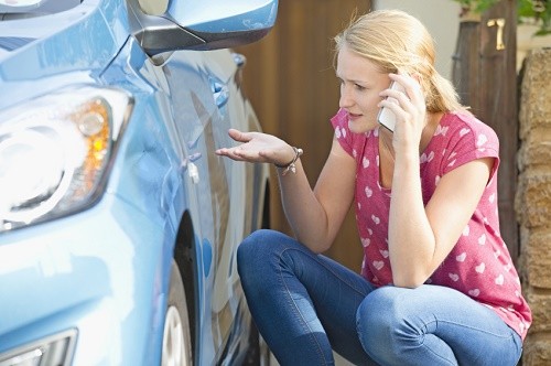 Woman Phoning Insurance Company To Report Car Damage