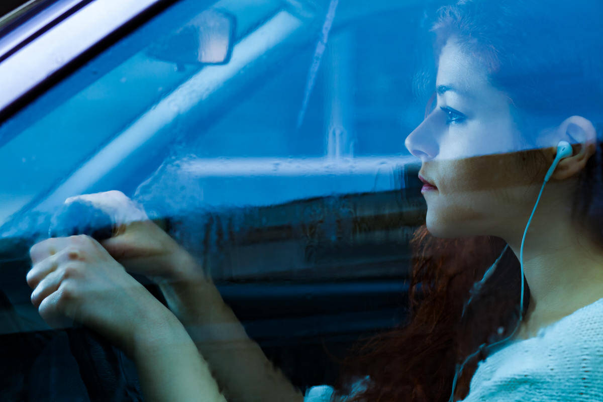 girl wearing headphone while driving