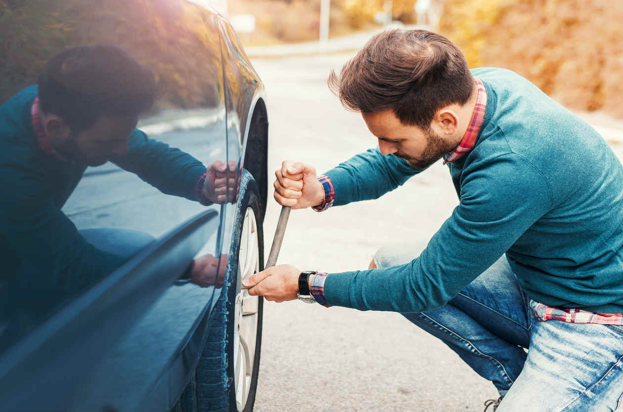 St Louis man changing flat tire