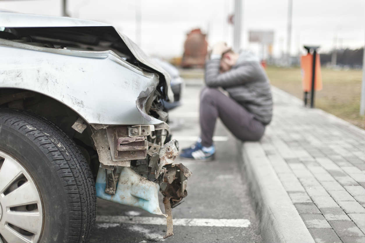 St. Louis man next to car after a crash