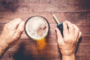 man holding a beer and car key
