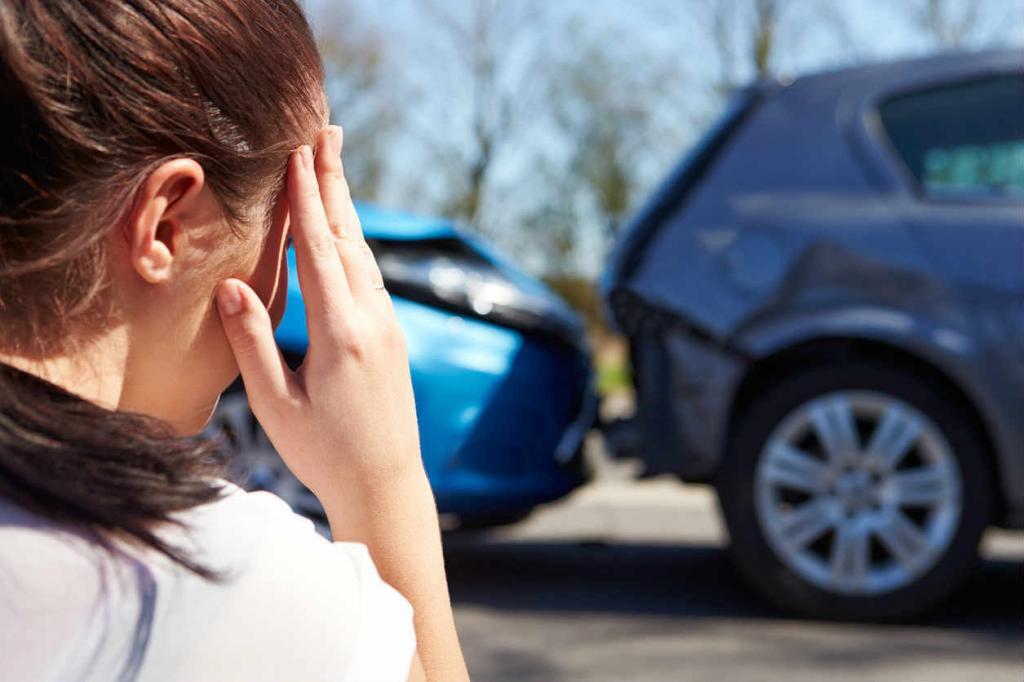 woman holding head after car accident