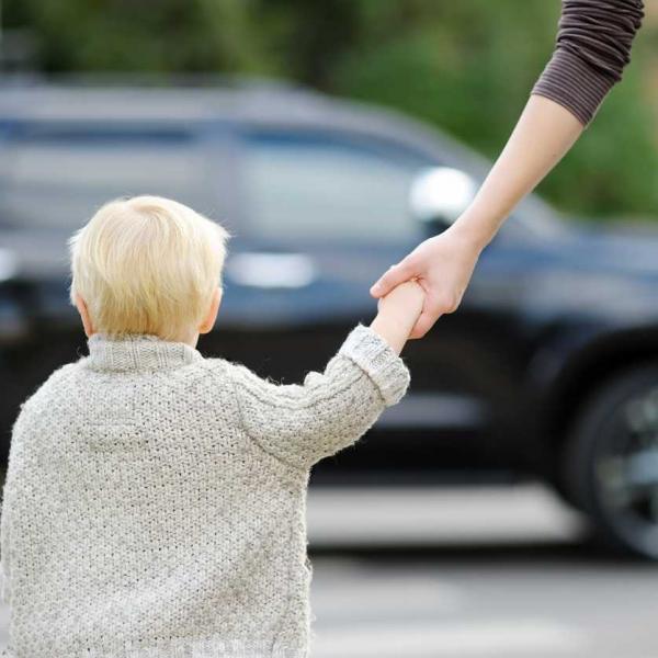 st. louis child crossing the street holding his mom's hand