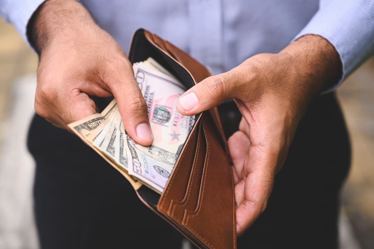 st louis man putting cash in his wallet after car accident