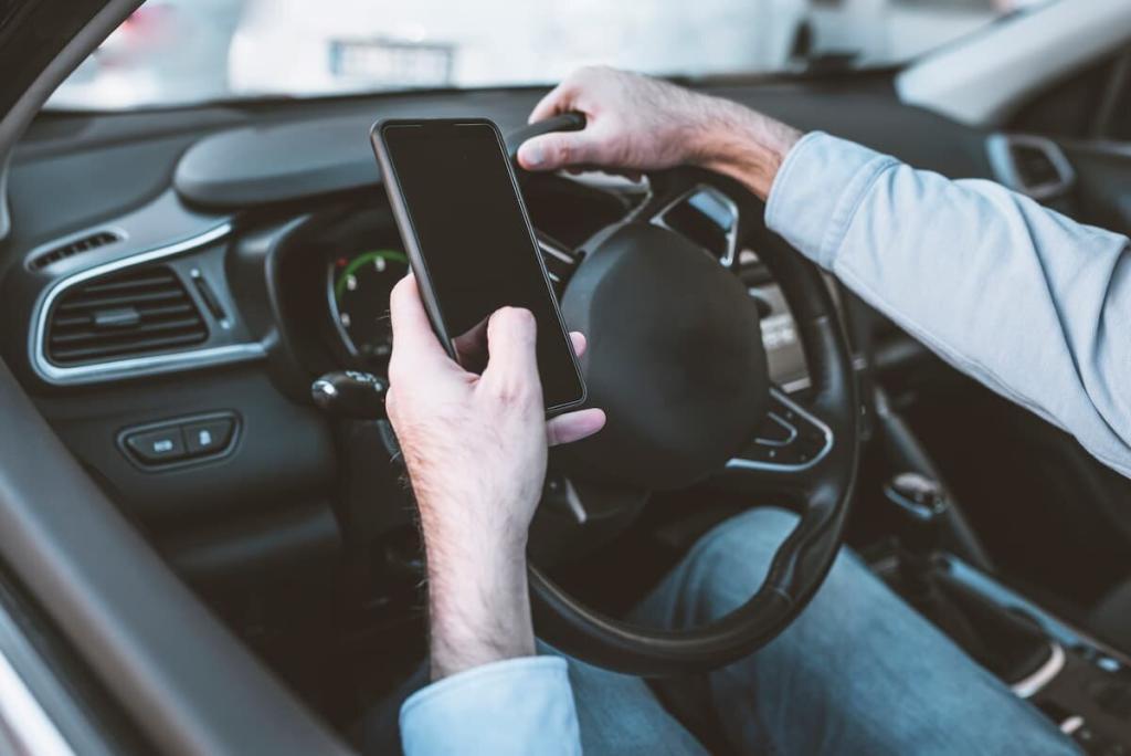 driver texting with one hand on the wheel