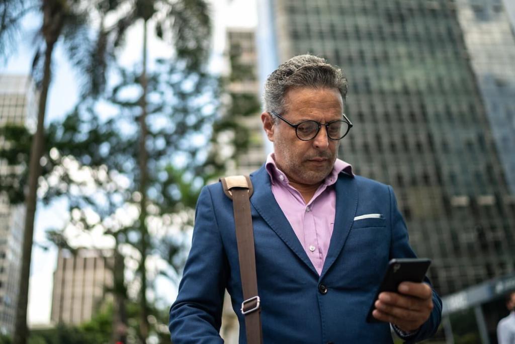 distracted man looking at his phone while crossing the road