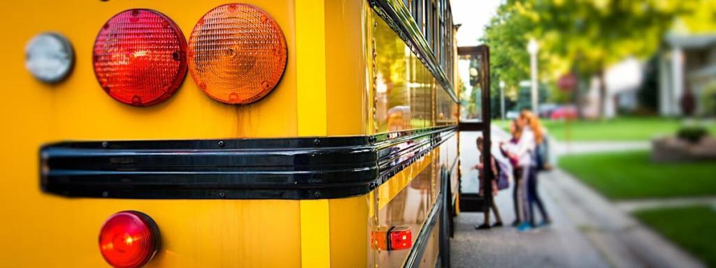 children getting on a school bus