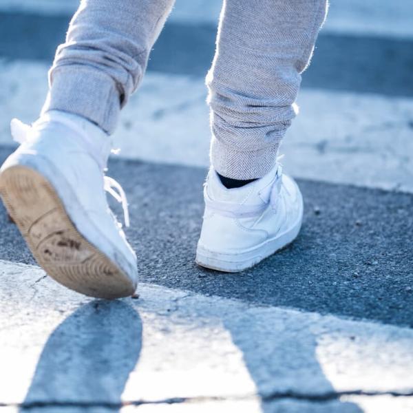 the shoes of a child crossing the road