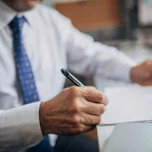 St. Louis car accident lawyer reviewing and signing legal documents at a desk.