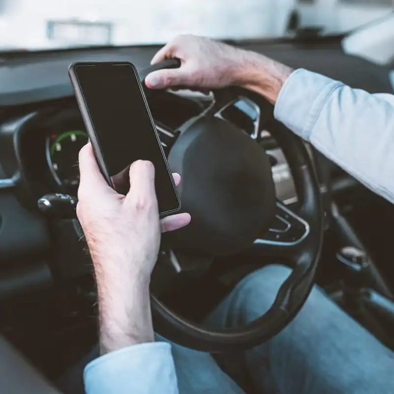driver texting with one hand on the wheel